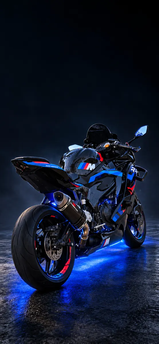Vista trasera de una superbike BMW M 1000 RR negra y azul con luces inferiores azules brillantes estacionada sobre asfalto mojado.
