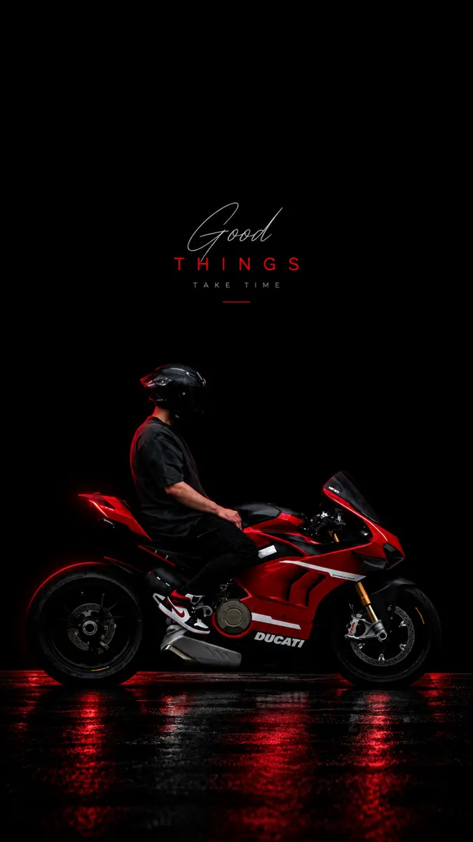 Una persona con casco y ropa negra sentada en una motocicleta Ducati roja en un estudio oscuro