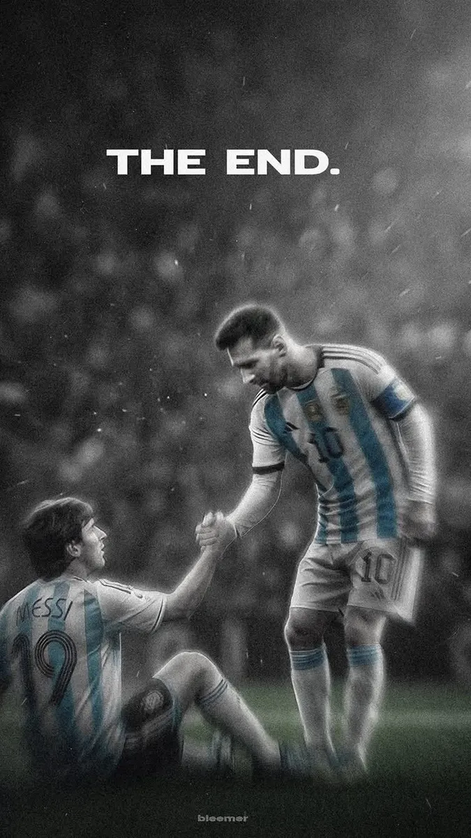 Lionel Messi con su camiseta de Argentina ayudando a levantarse del suelo a su versión más joven con la camiseta número 19 en un campo de fútbol.